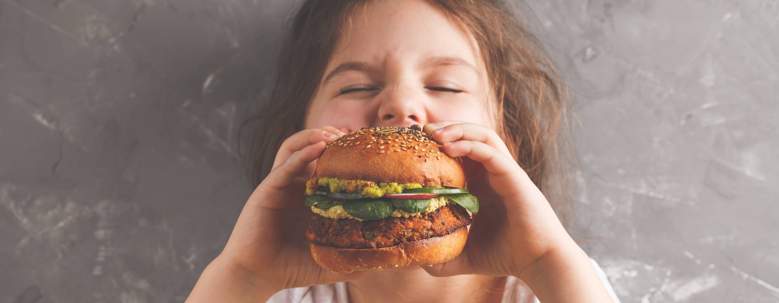 Ung barn äter hamburgare