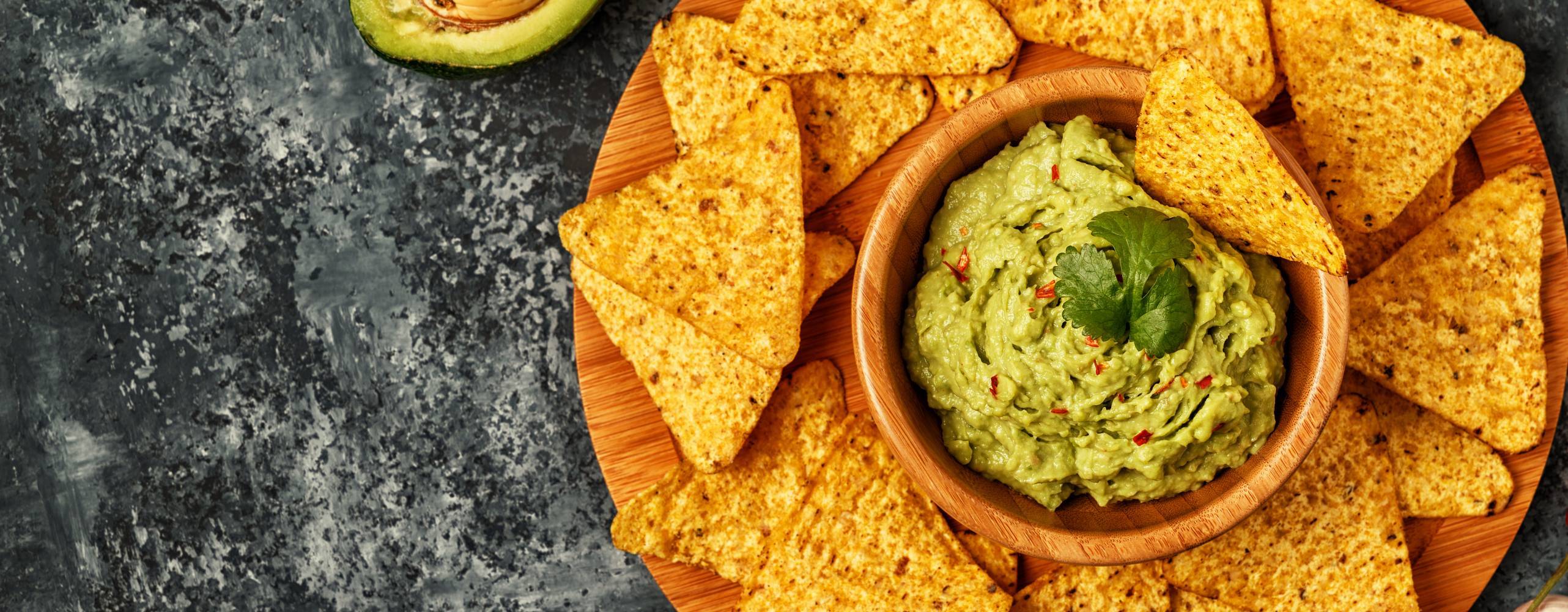 Nachos i en tallrik med guacamole i mitten