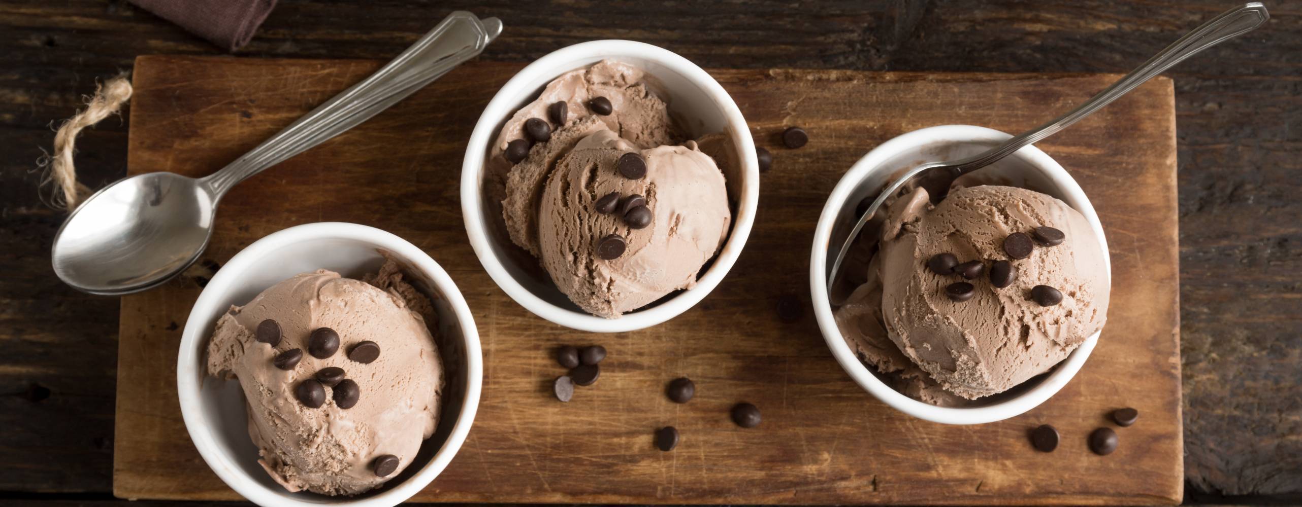 Tre bägare glass med kaffeglass på en träbräda