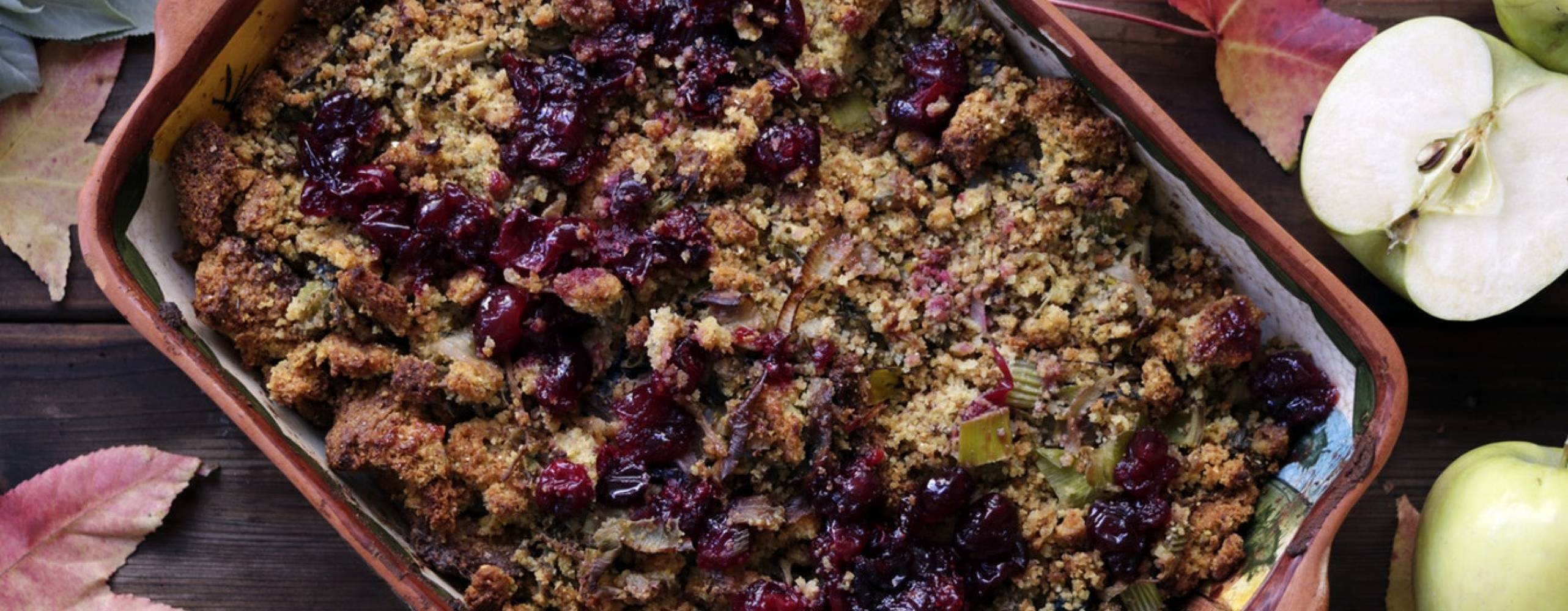 Blåbärspaj på ett bord, bredvid ligger äpplen och lönnlöv.