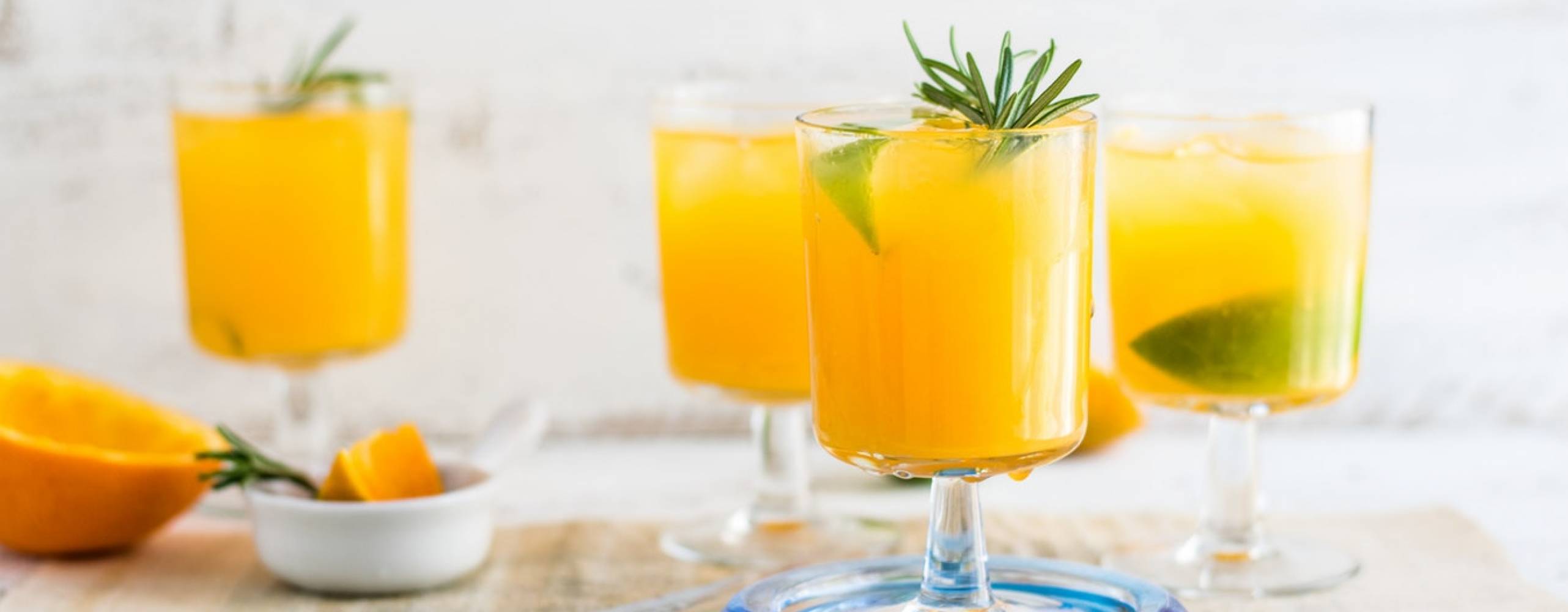 Fyra glas med juice på ett vitt bord