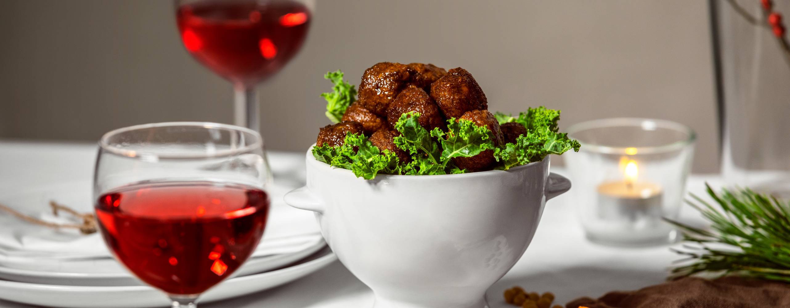 Veganska köttbullar i en vit skål på ett dukat bord