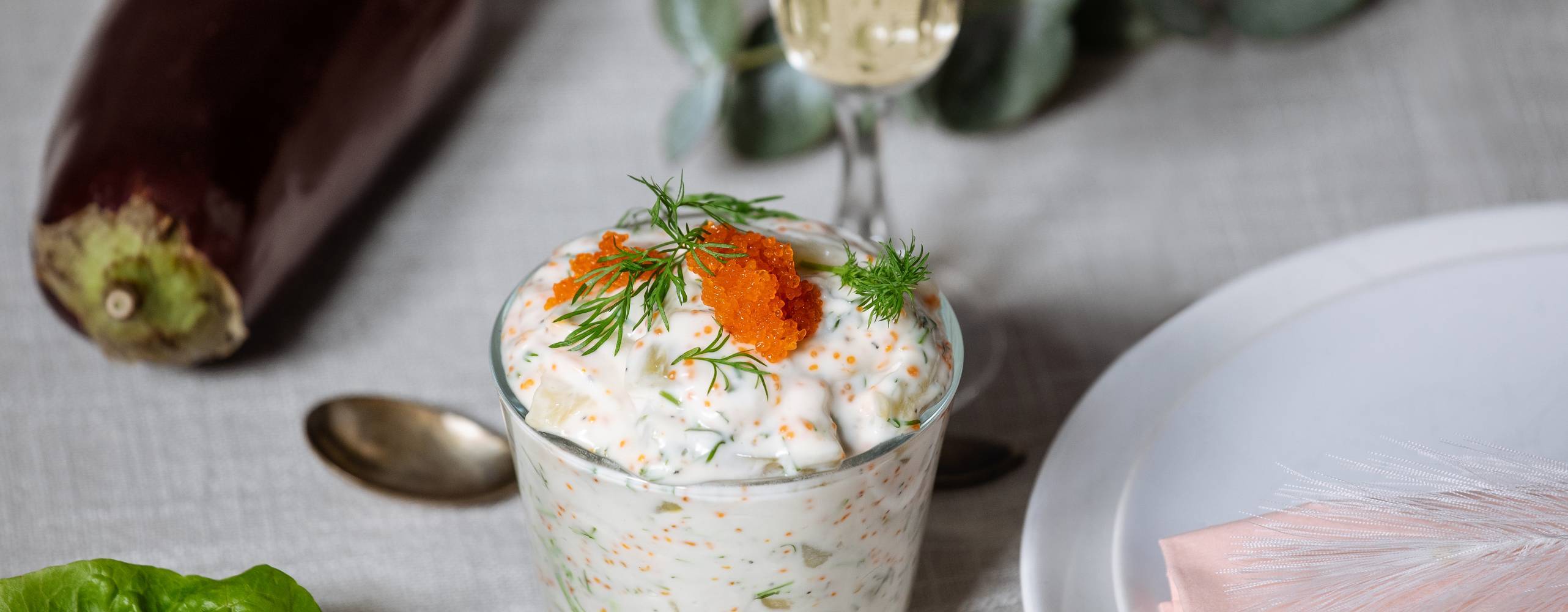 vegansk sill i ett glas på ett dukat bord.