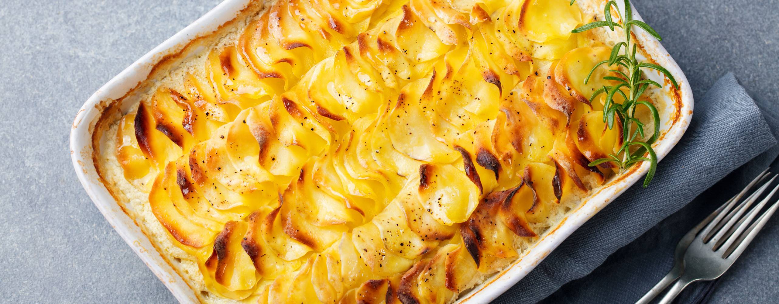 Potatisgratäng i en ugnsform på ett grått bord