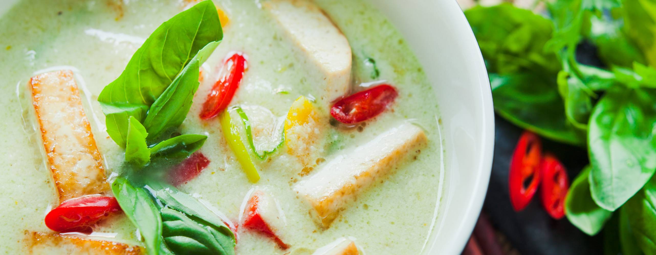 Skål med gröncurrysås och tofu.