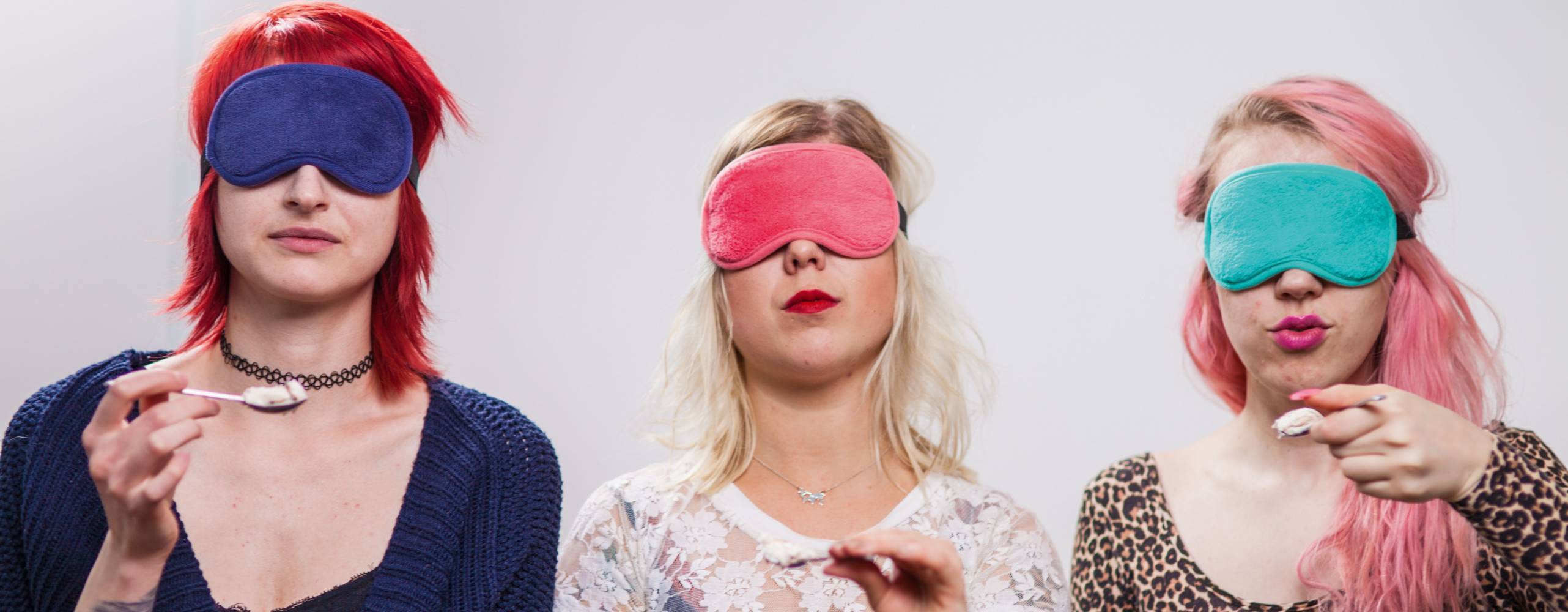 Tre personer sitter med ögonbindel och varsin sked glass.