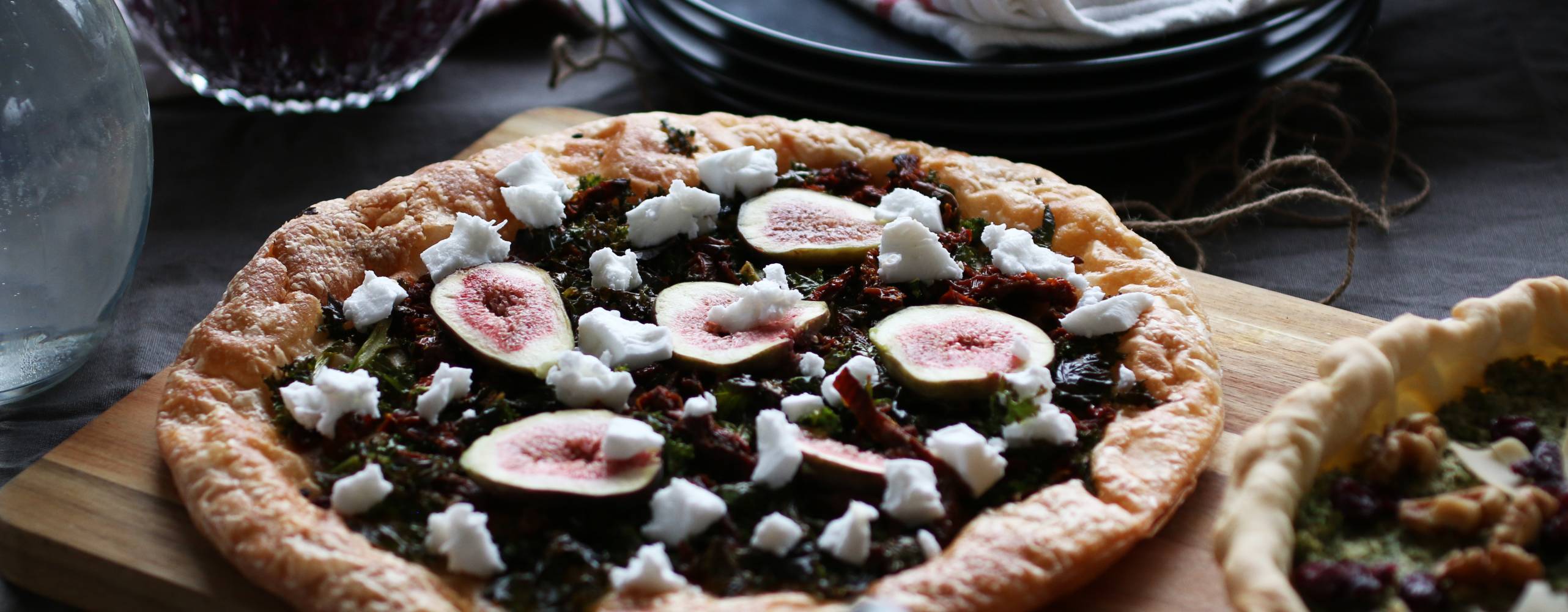 Smördegspaj med grönkål, soltorkade tomater, fikon och vegansk feta på en bräda