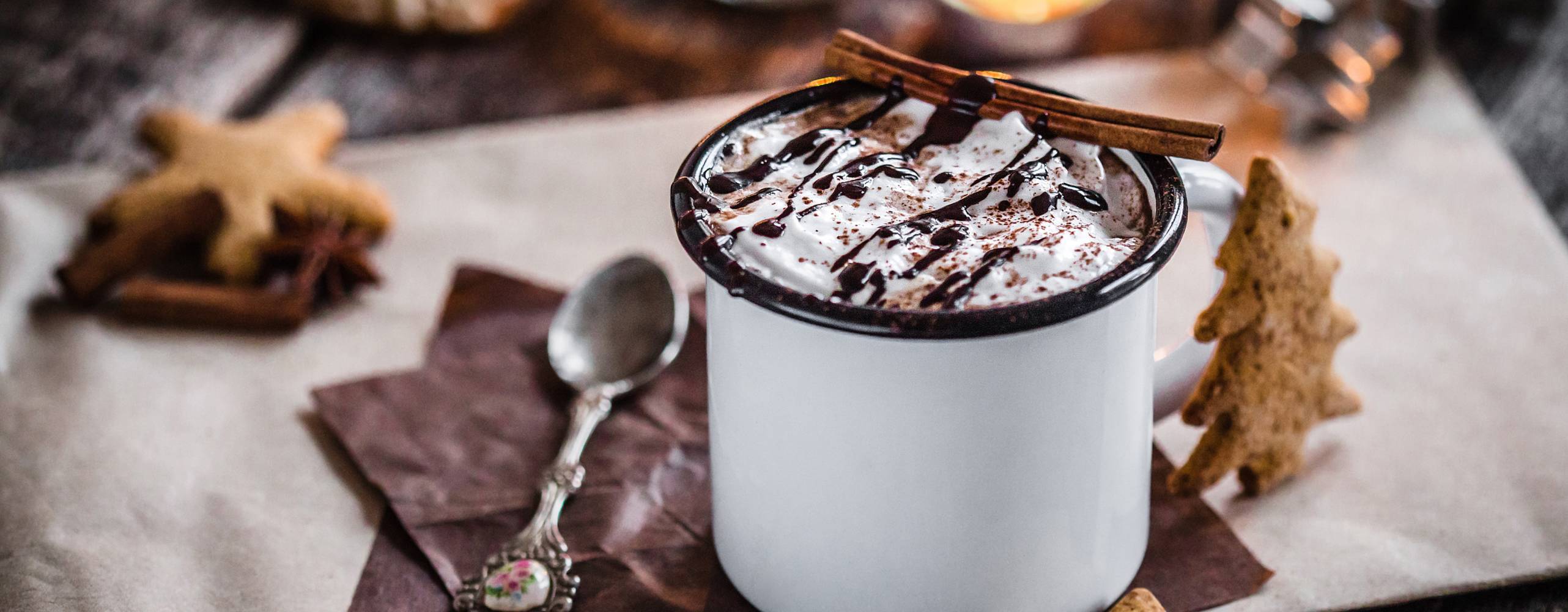 Vegansk varm choklad på ett bord omringad av pepparkakor