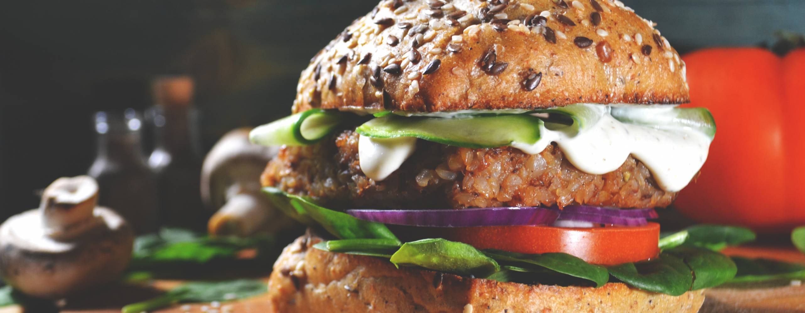 Vegansk burgare på en träbräda mot mörk bakgrund