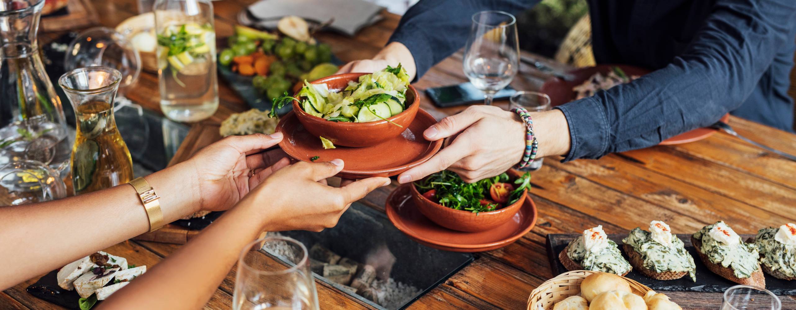 Flera personer runt ett bord delar på veganska rätter