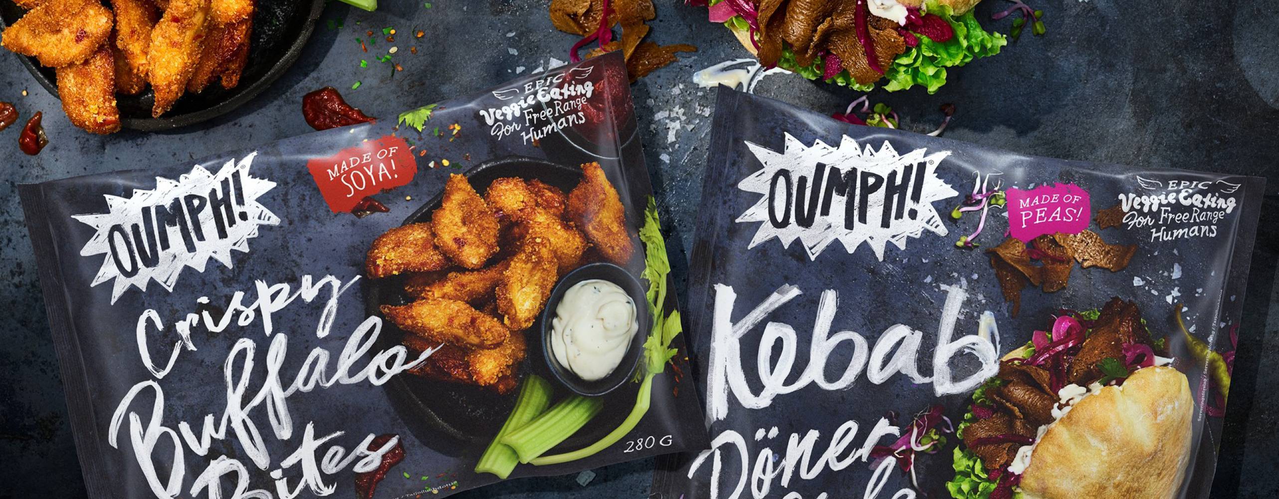 Två förpackningar med Oumph! Crispy Buffalo Bites samt Oumph! Kebab Döner Style. Vid sidan av finns produkterna upplaga för servering.