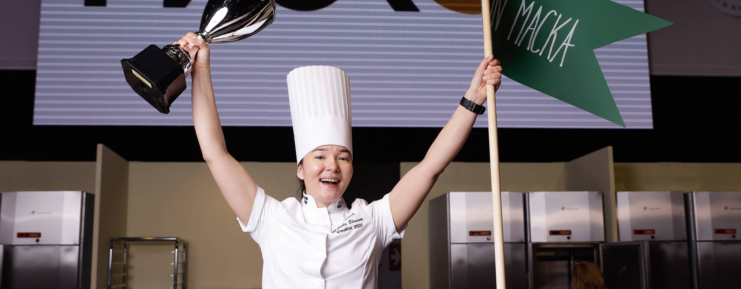 Mikaela Eliasson, vinnare av Mack-SM 2021, med pokal och flagga i händerna.
