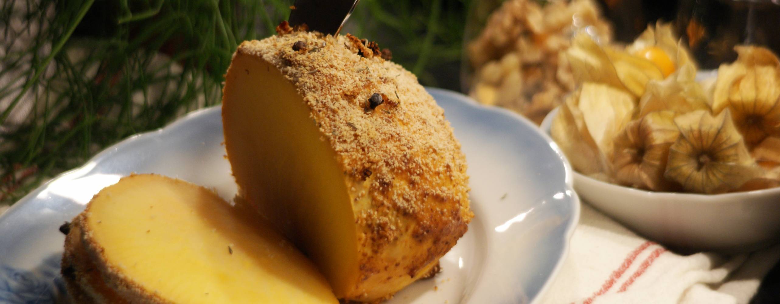 Griljerad kålrot på fat med juliga dekorationer och tillbehör i bakgrunden