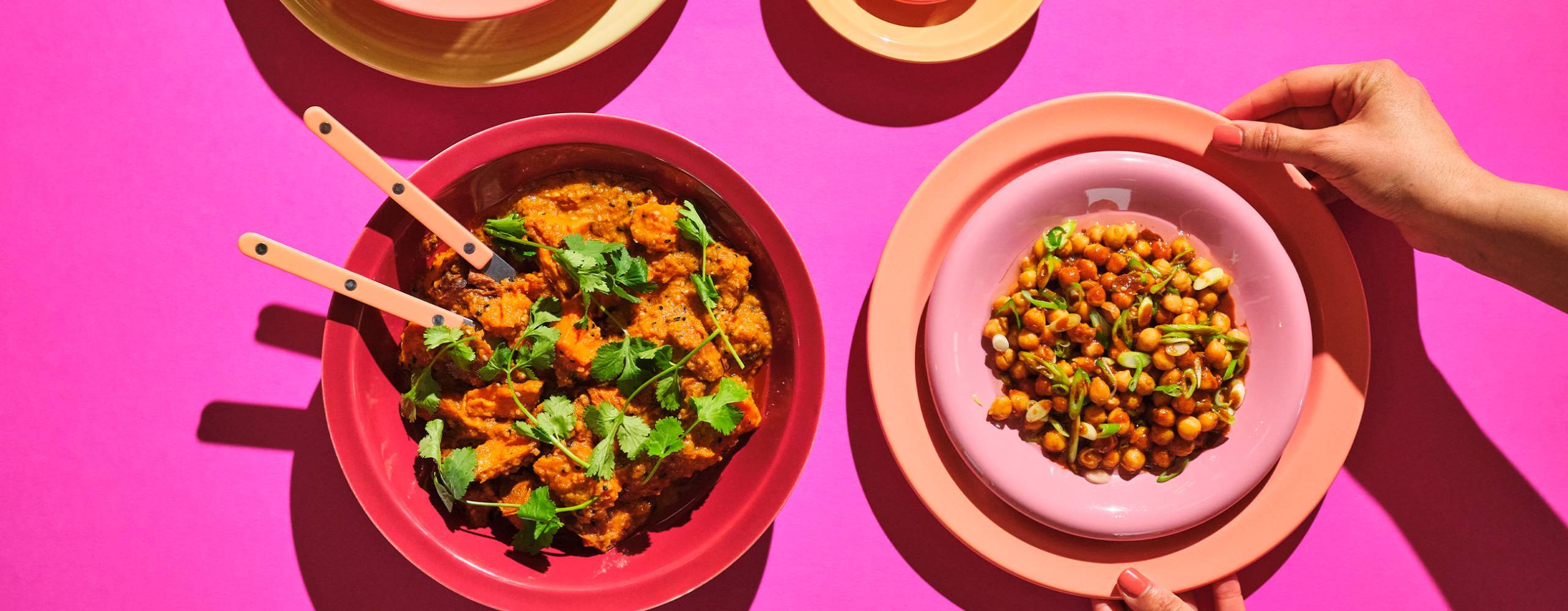 Växbaserade måltider på 4 olika tallrikar mot en rosa bakgrund.