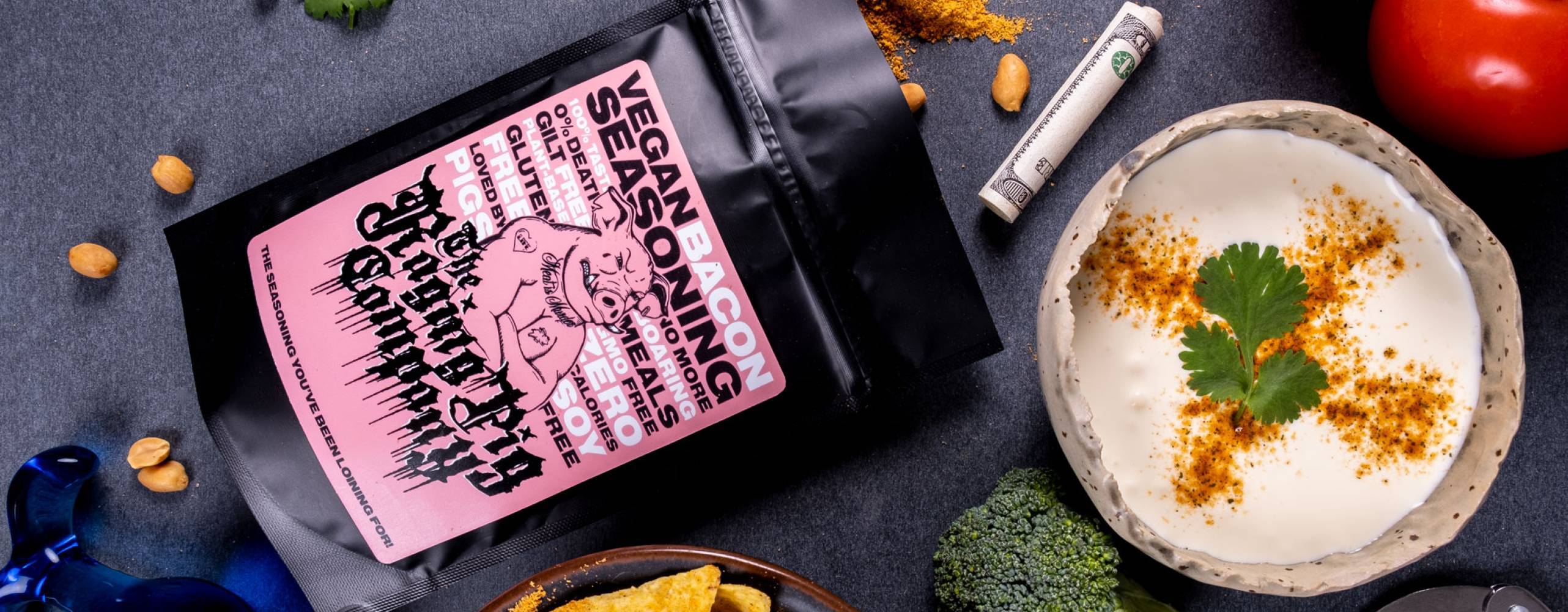 Kryddpåse, dip och nachos utplacerade på ett svart bord.