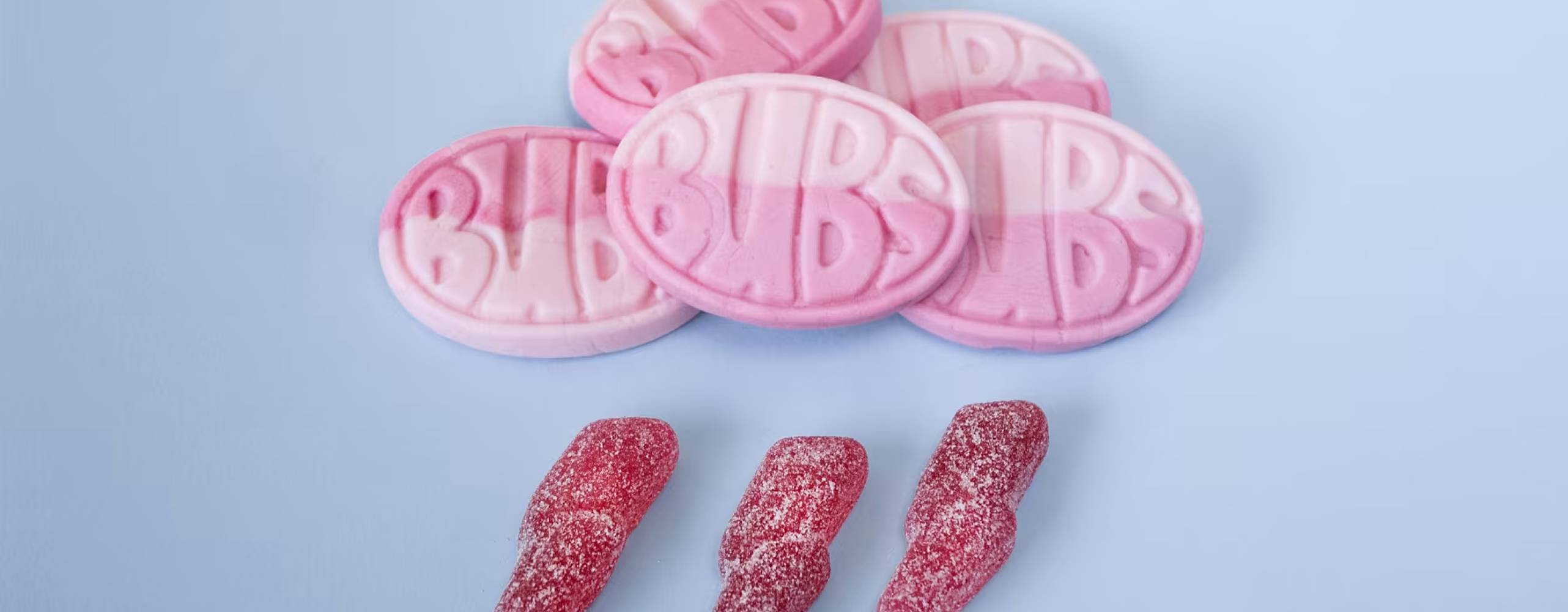 rosa godisar i två olika högar mot en ljusblå bakgrund