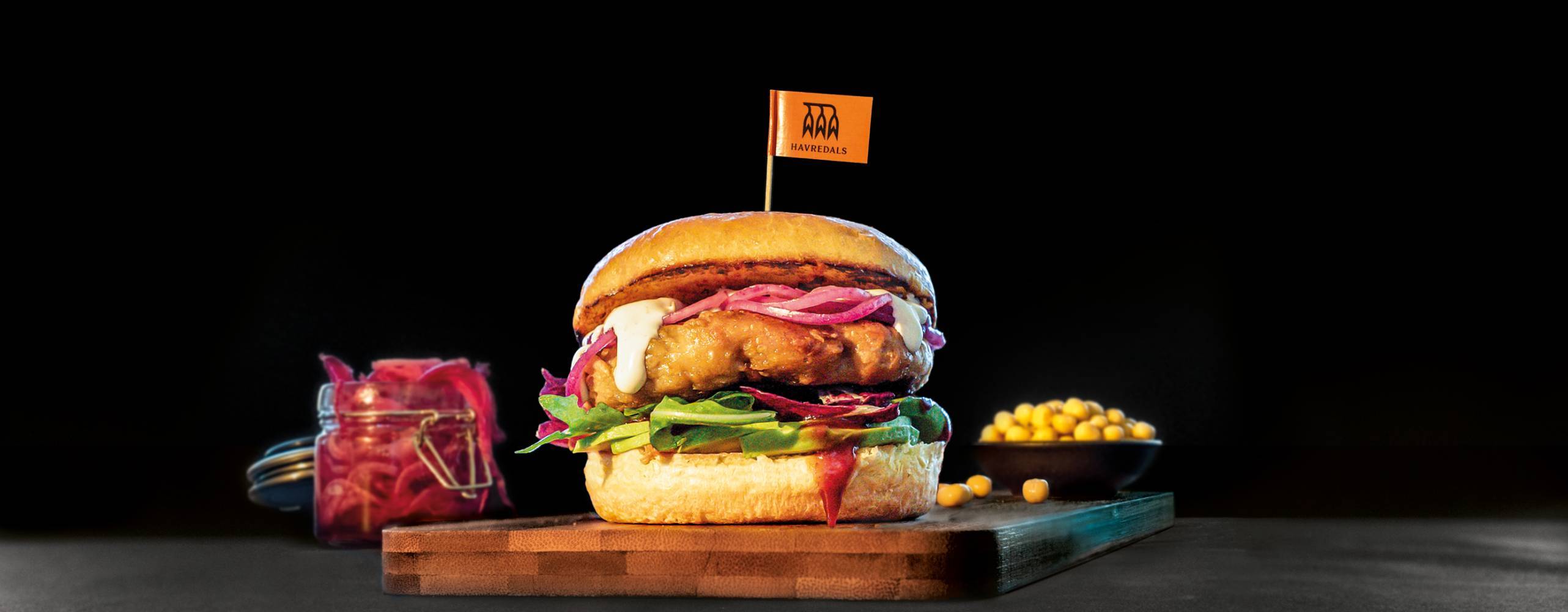 En Växtbaserad kycklingburgare mot en svart bakgrund.