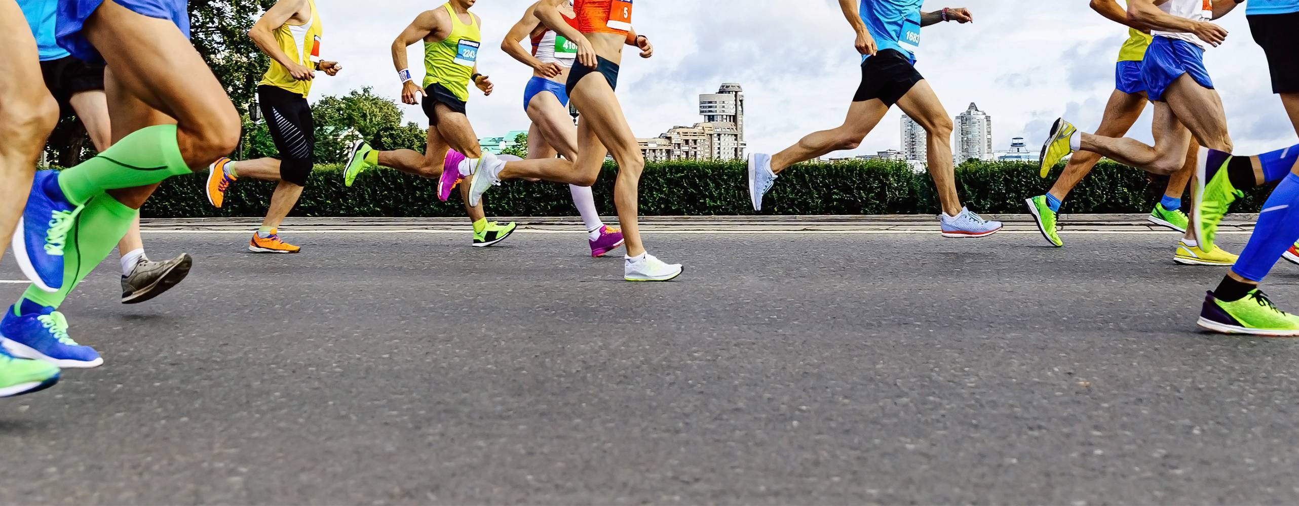 grupp idrottare löpare: män och kvinnor springer stadsmaraton i bakgrunden av byggnader