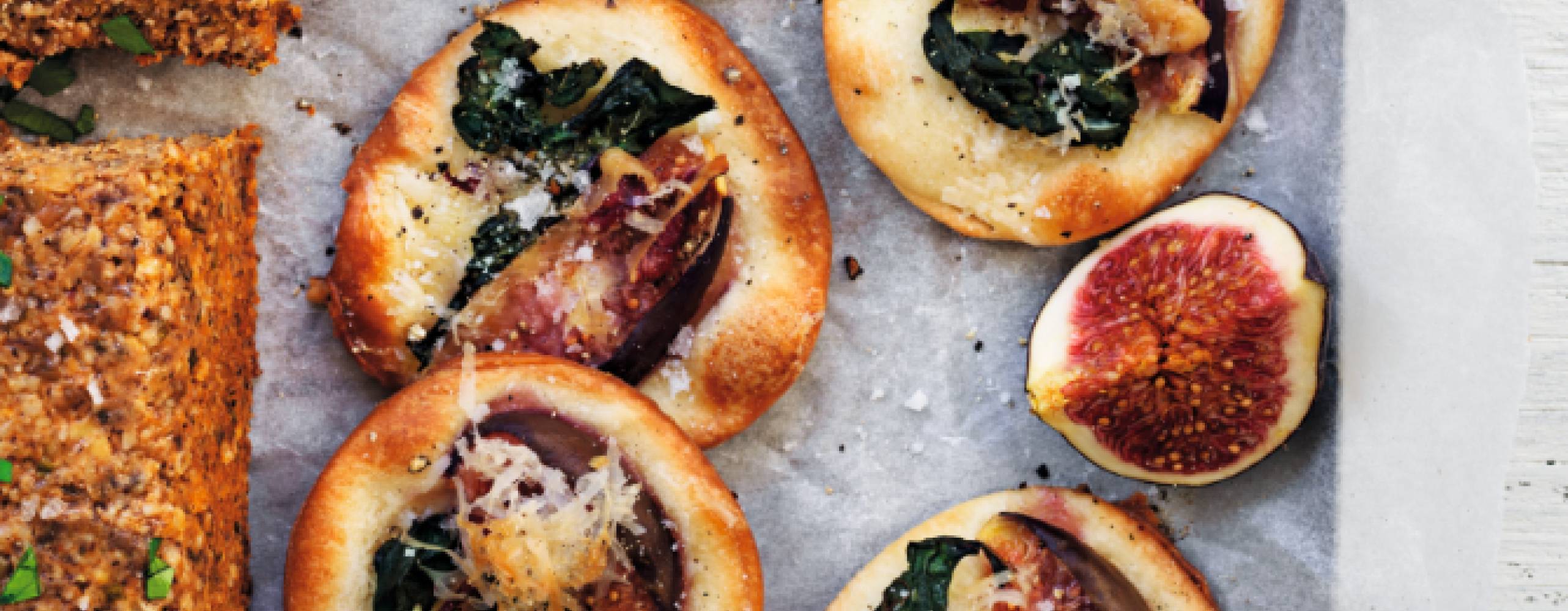 Minipizzor med svartkål och fikon på bakplåtspapper