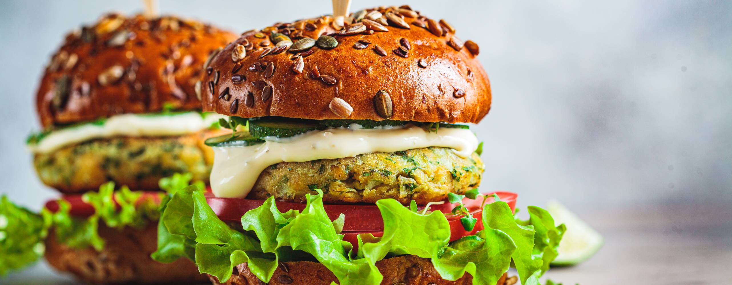 Vegan falafel burger med grönsaker och sås, mörk bakgrund. Hälsosam mat koncept.