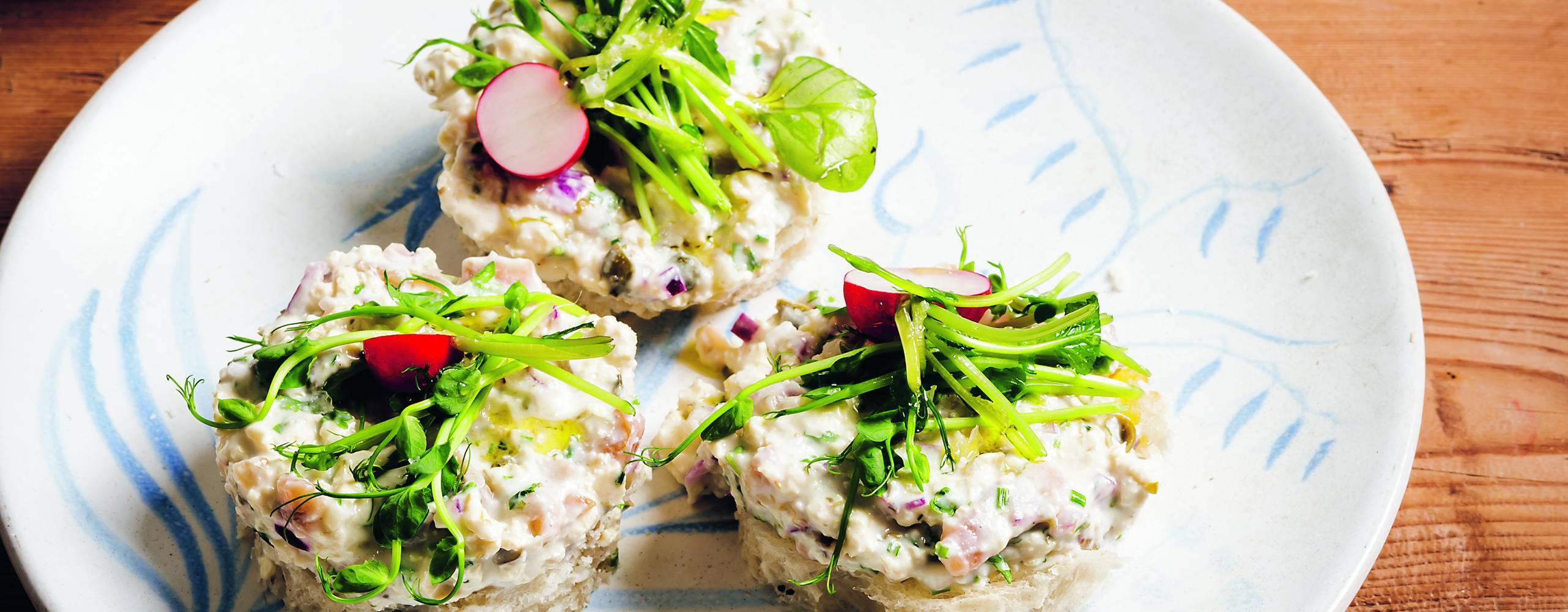 Gubbröra upplagt på tre runda bröd på en tallrik