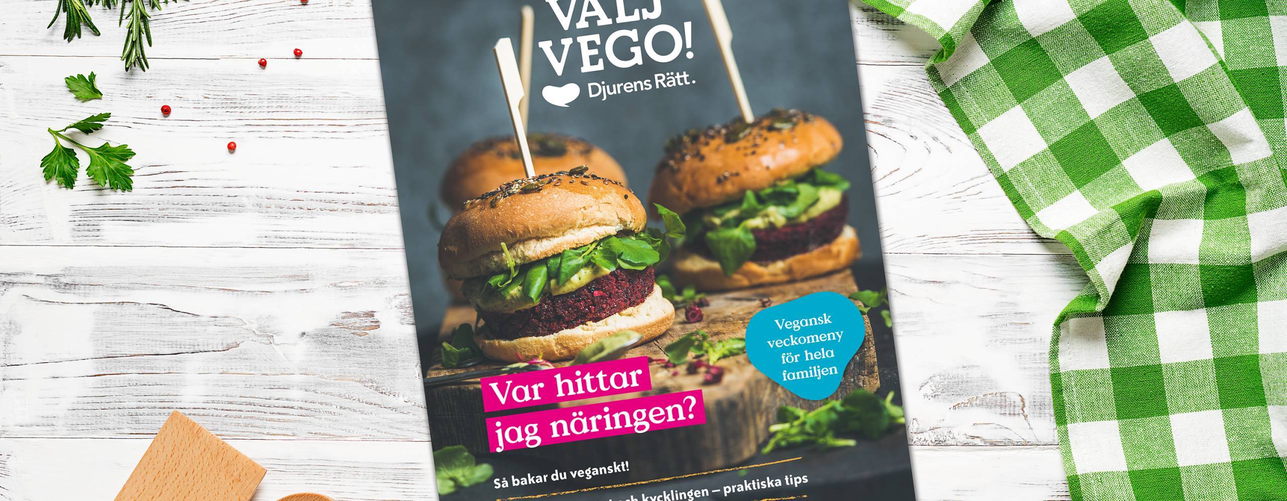En tidning på ett ljust bord med en grönrutig duk på sidan