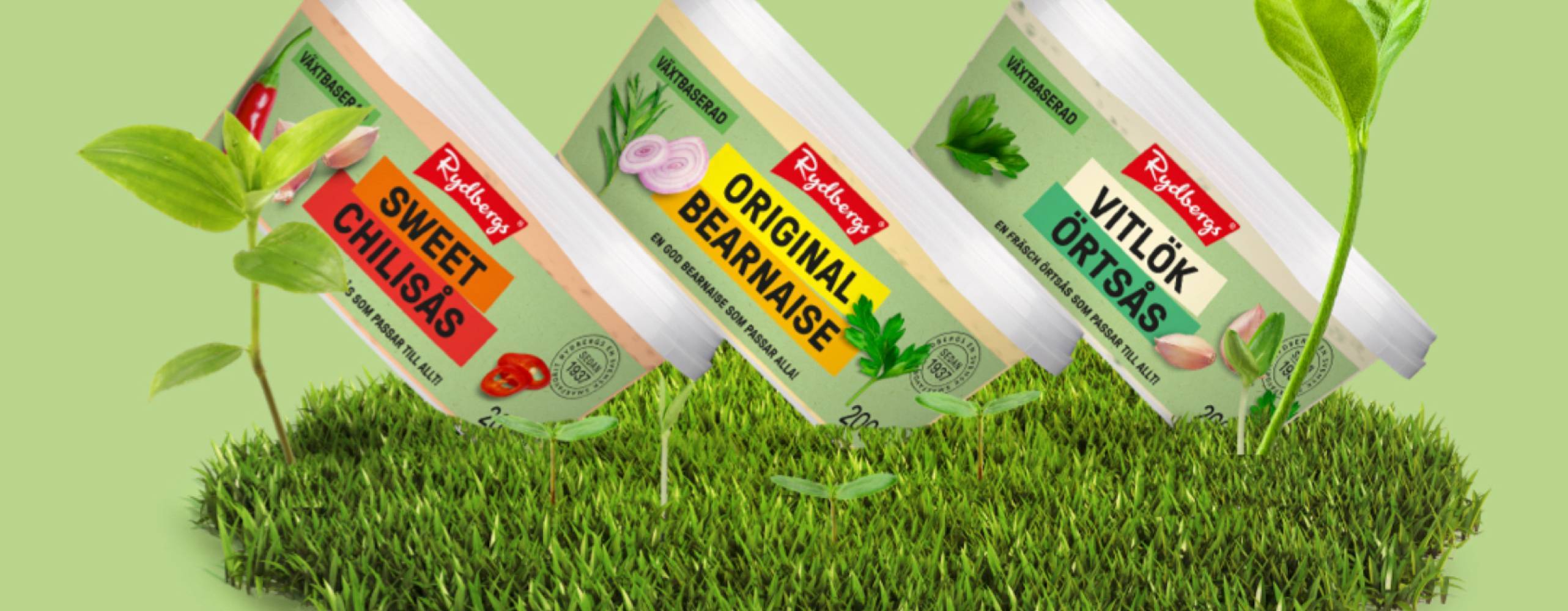 tre plastburkar med sås snedställda mot en grön bakgrund med gräs