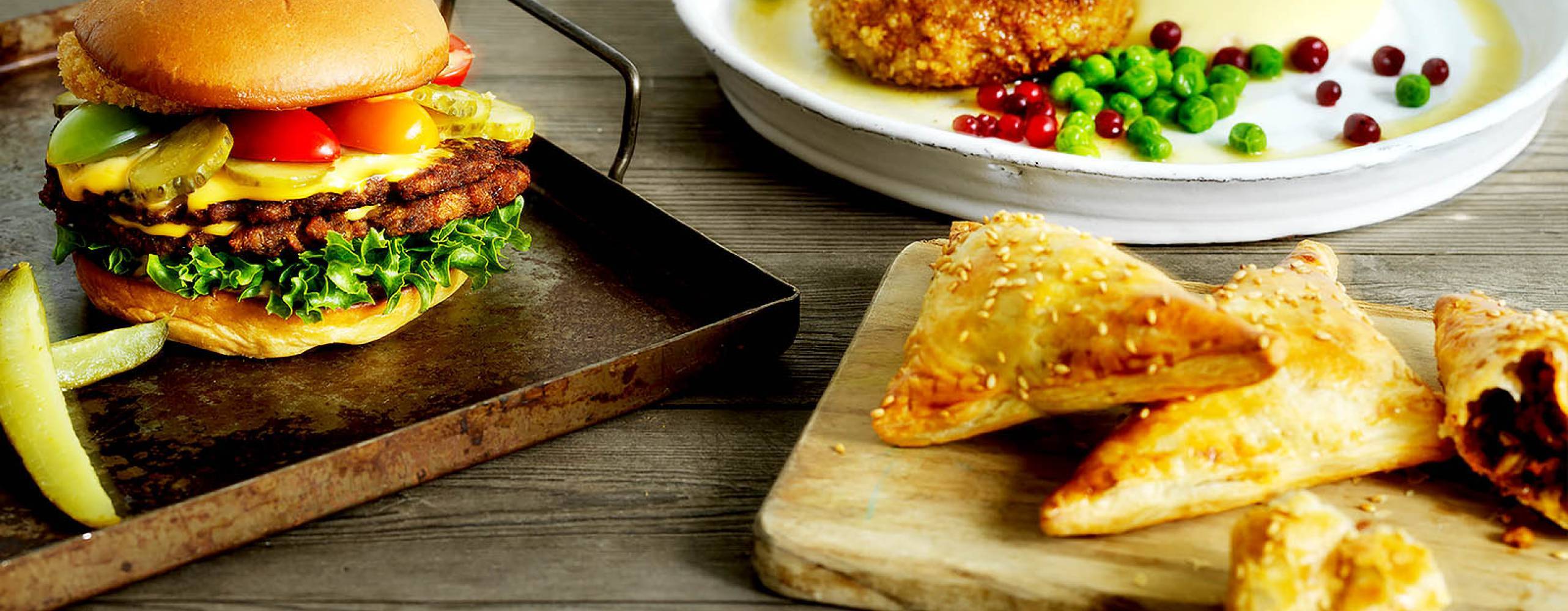 Burgare, biff med potatismos och snittar, alla gjorda på formbar baljväxtfärs, uppdukade bredvid varandra.