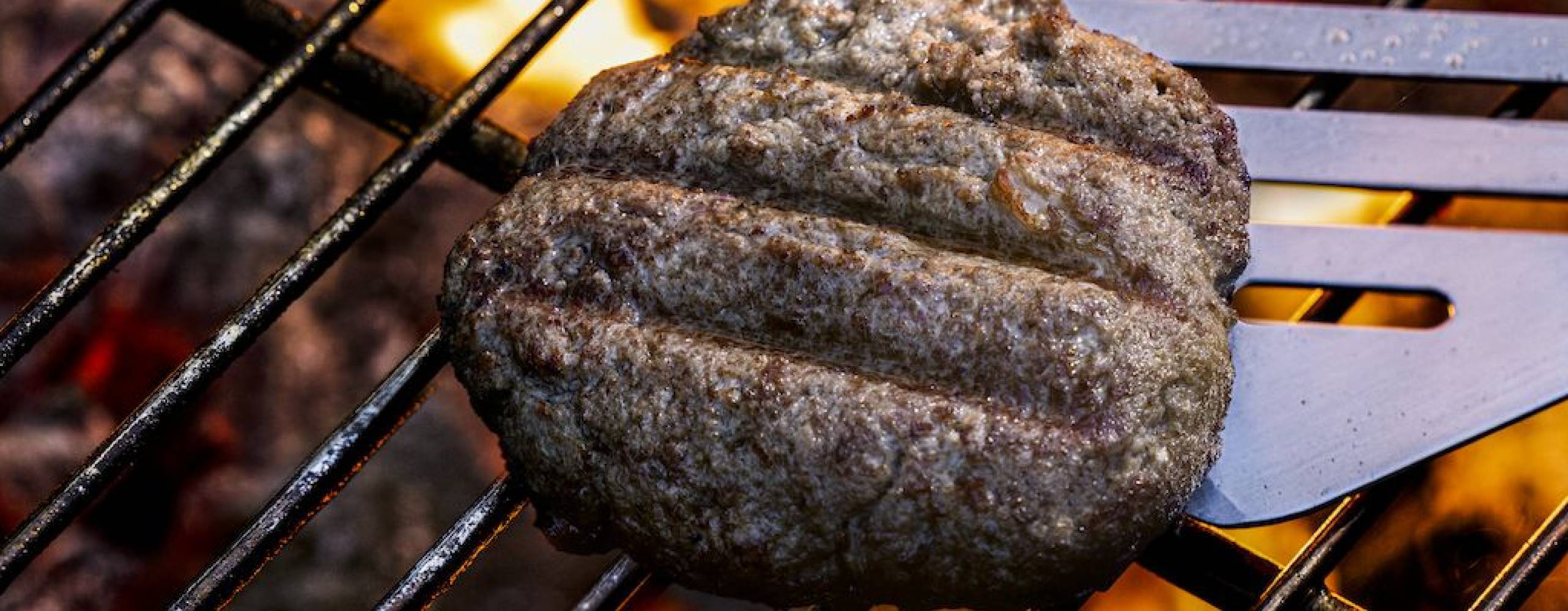 Odlad köttburgare på grillen