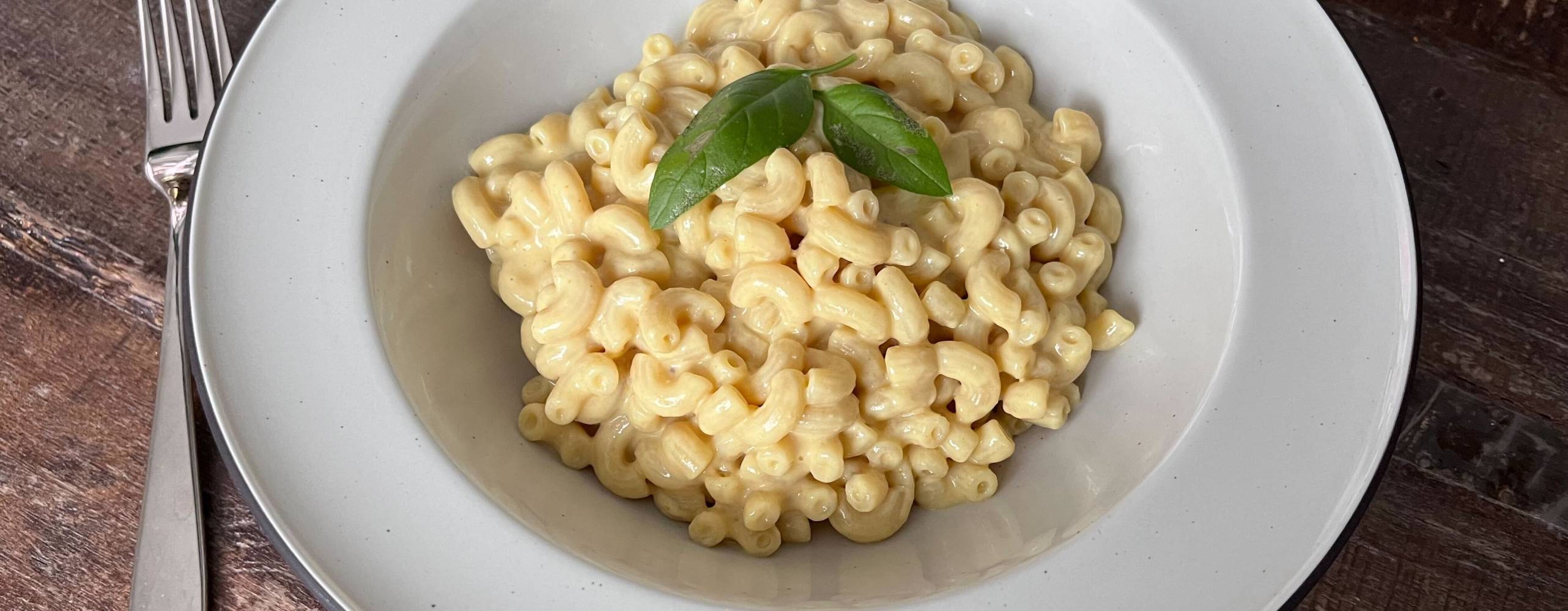 En tallrik med pasta på ett träbord.