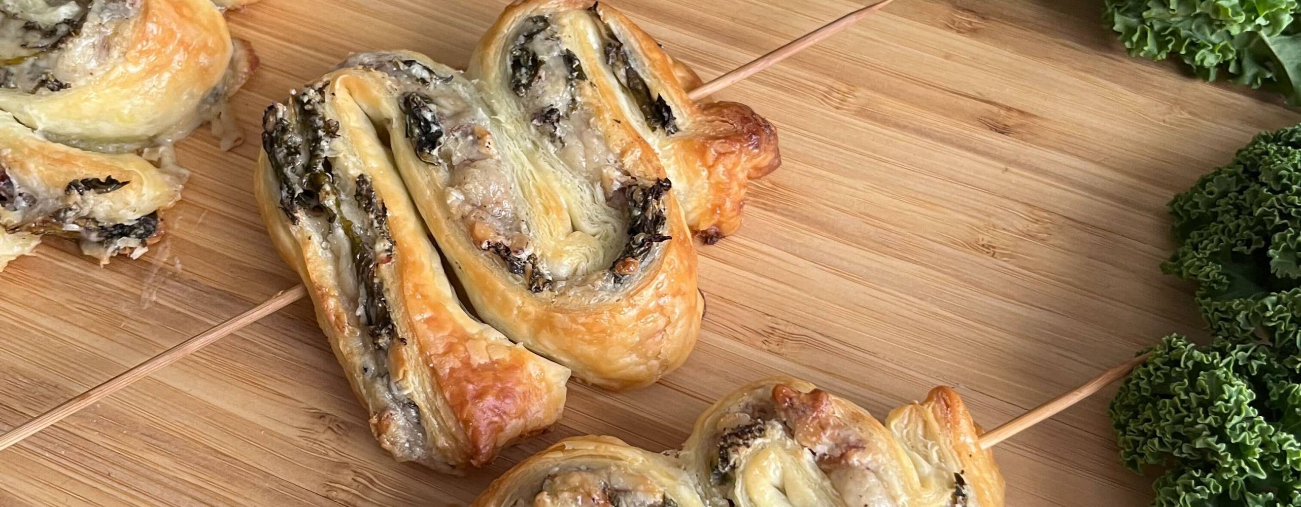 Tre grönkålsgranar på en skärbräda i trä med grönkål runt