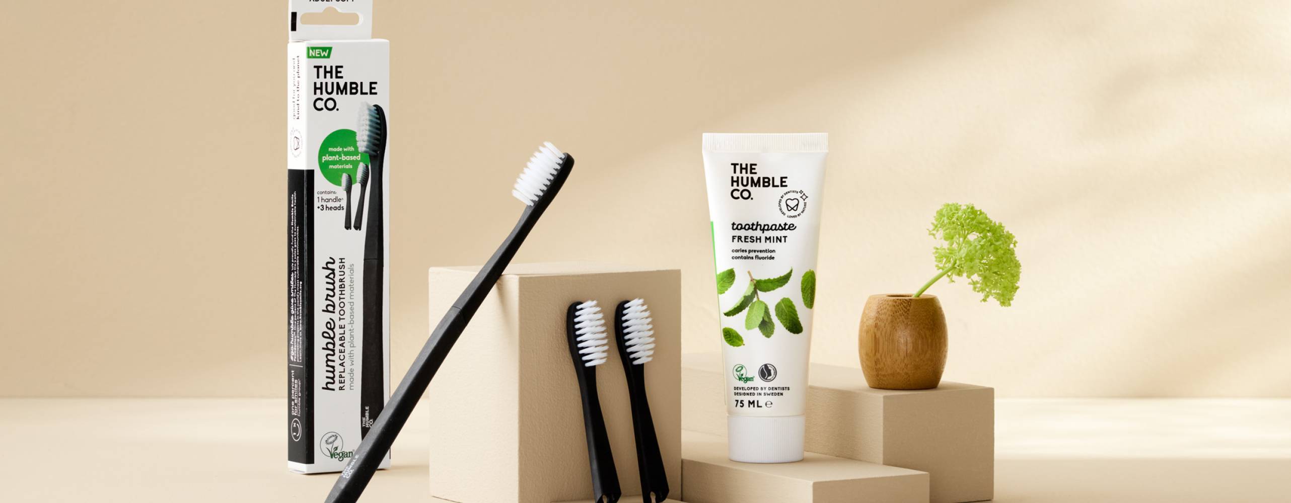 Tandborstar och tandkrämer som är placerade mot en beige bakgrund