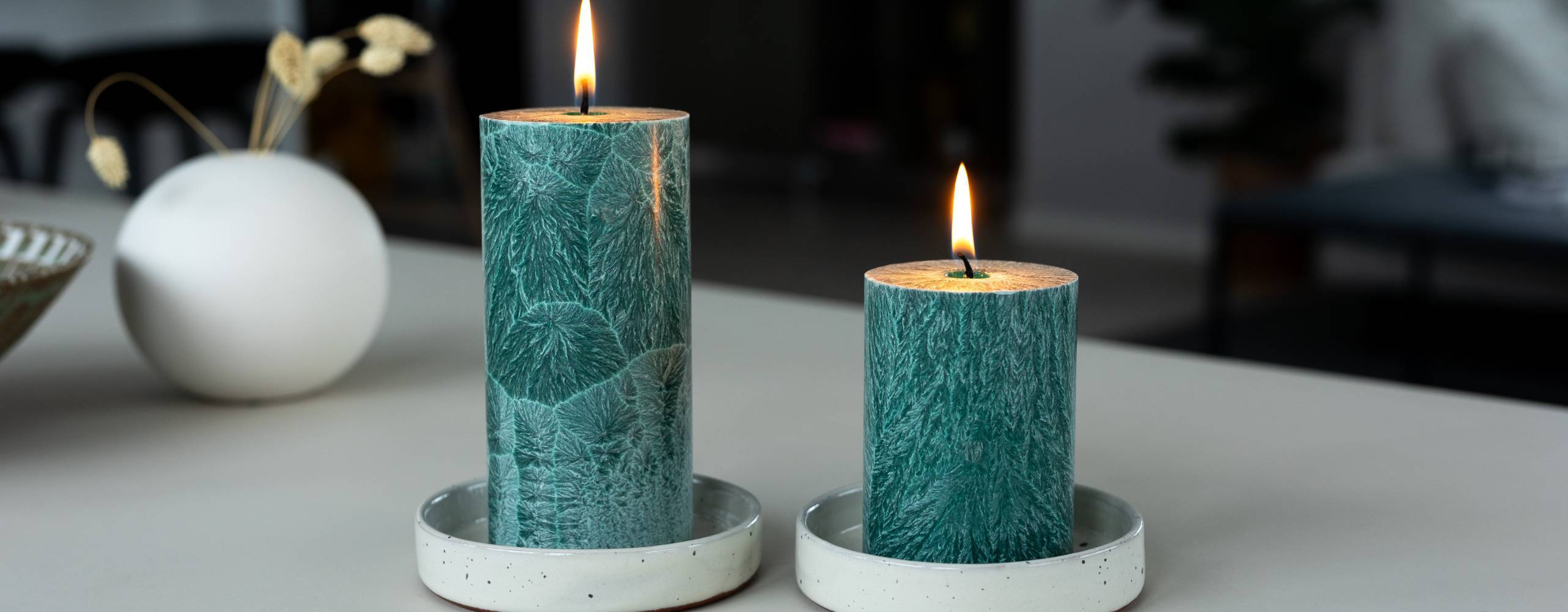 Två tända blockljus på ett bord