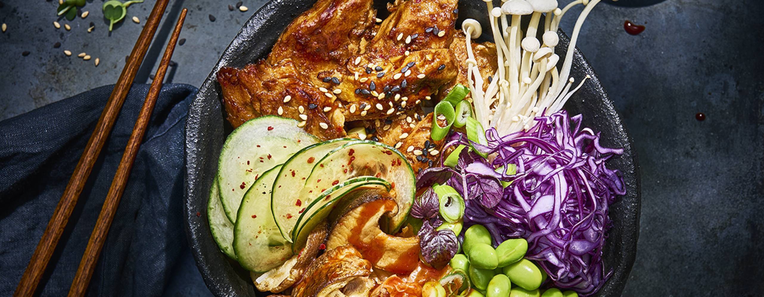 Koreansk grönsaksbowl i en svart djuptallrik på ett svart bord