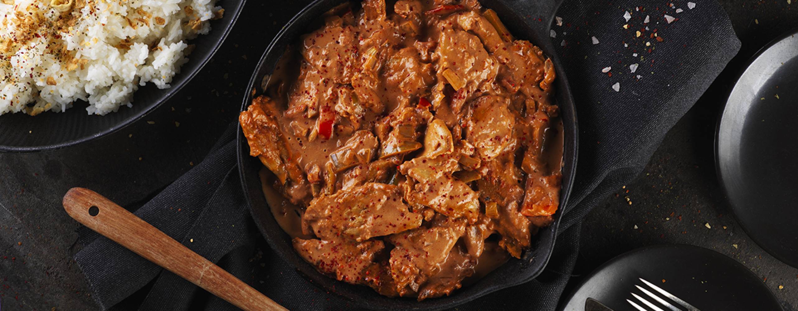 Vegansk stroganoff i en gryta på ett svart bord