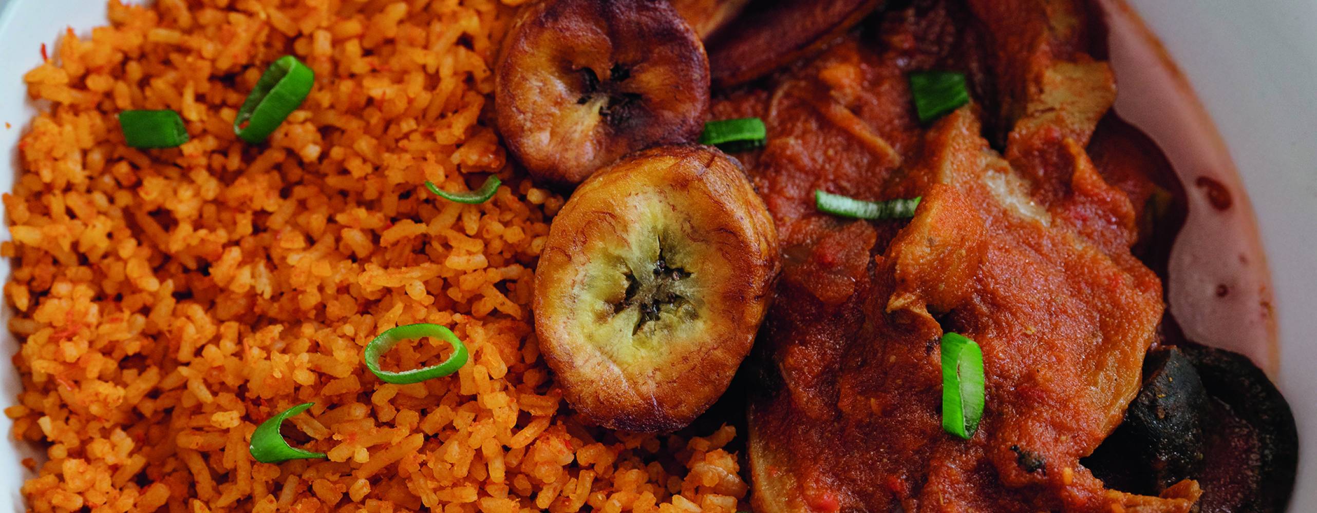 Jollof ris med stekt kokbanan i en djuptallrik