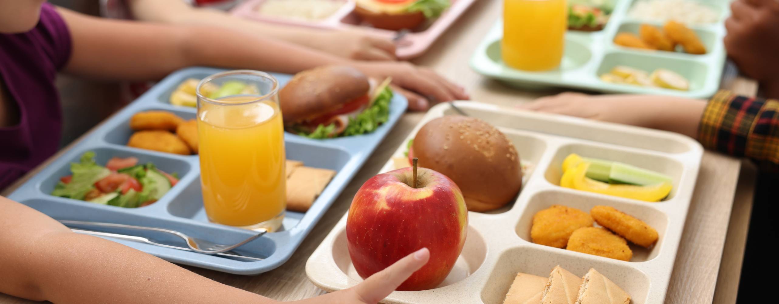 Små barn äter lunch på träbord i skolmatsalen, närbild
