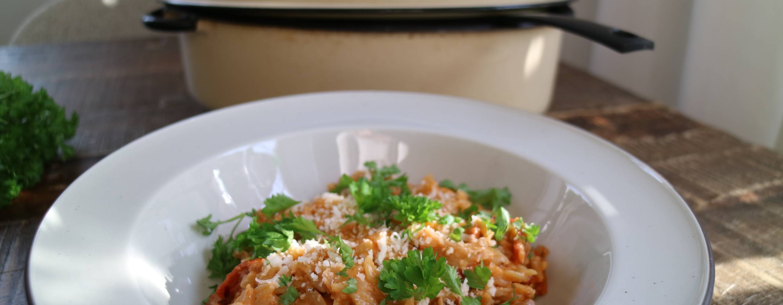 En tallrik risoni framför en gryta