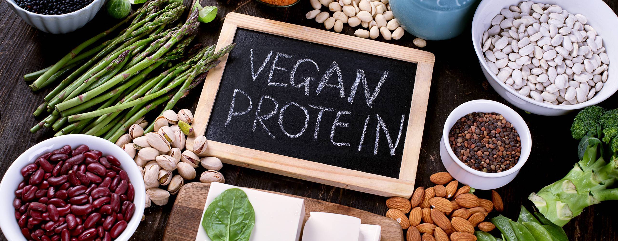Bild på svart skrivtavla med texten vegan protein, omringad av diverse grönsaker